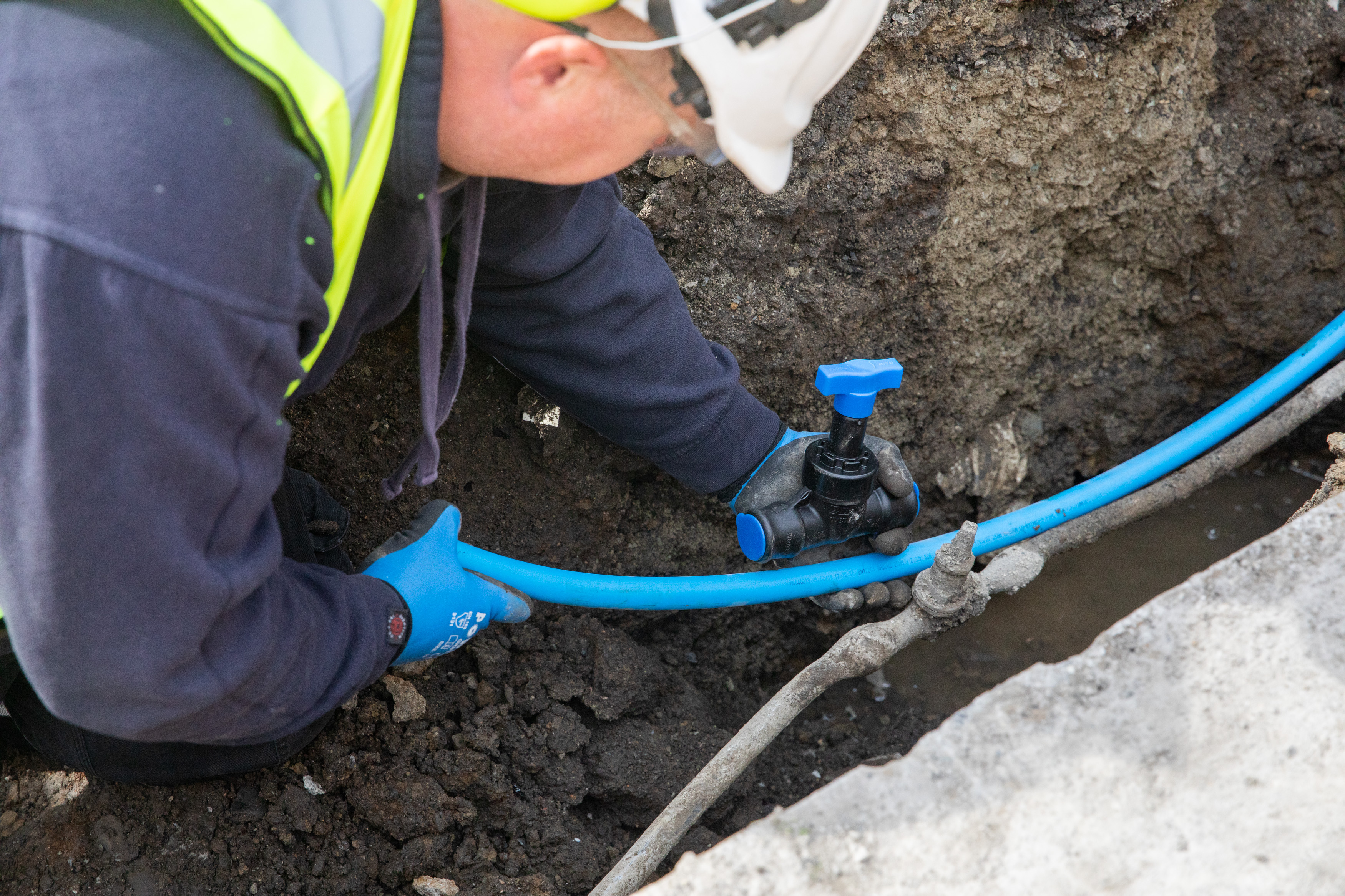 An Uisce Éireann worker fitting a new pipe in the ground