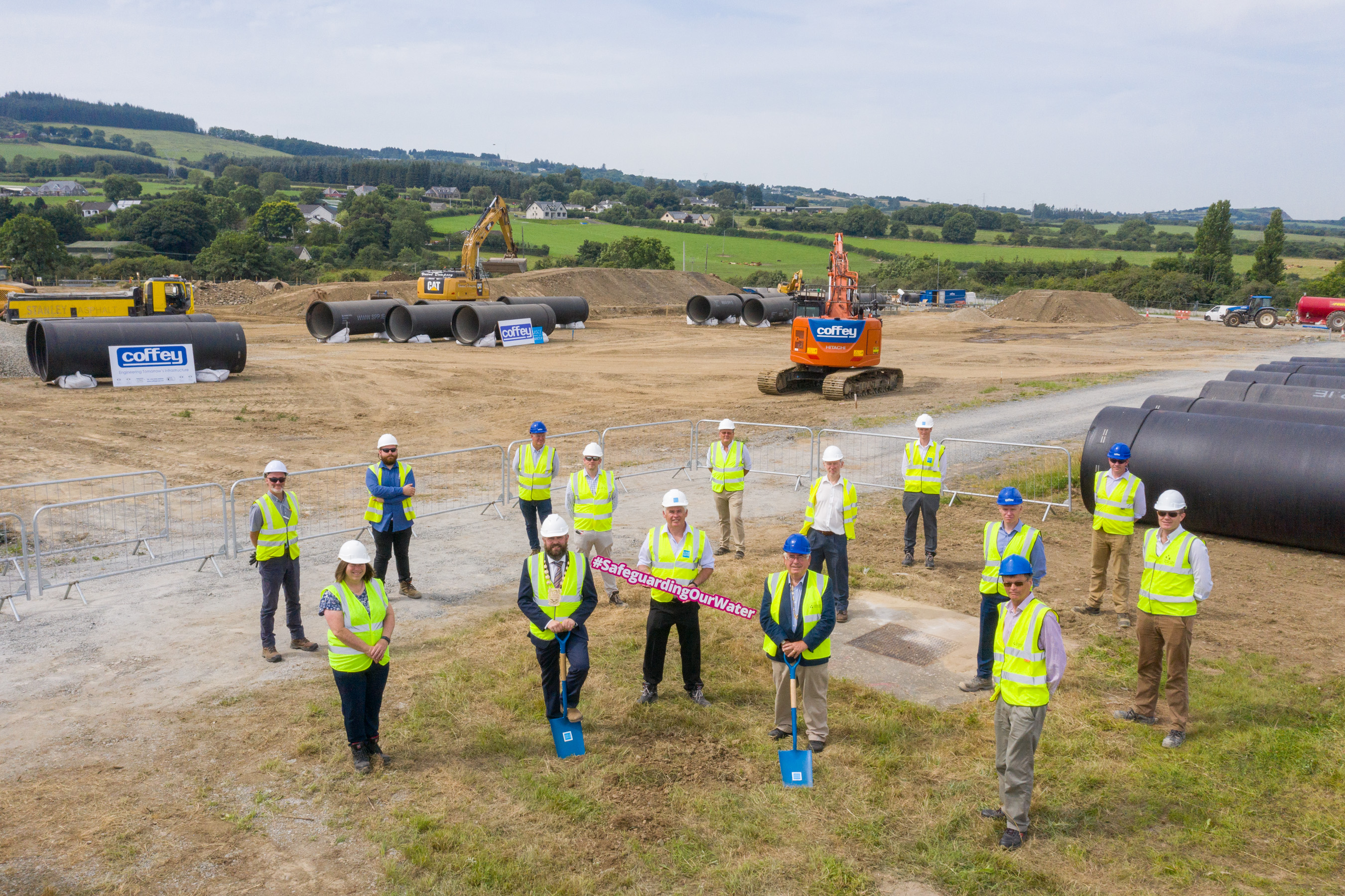 A group of people in hi-vis jackets and hard hats on a construction site