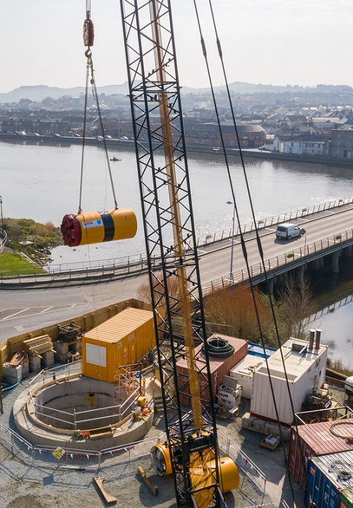 A crane carrying a piece of pipe