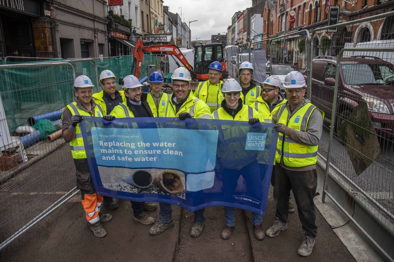 A group of Uisce Éireann workers holding a banner