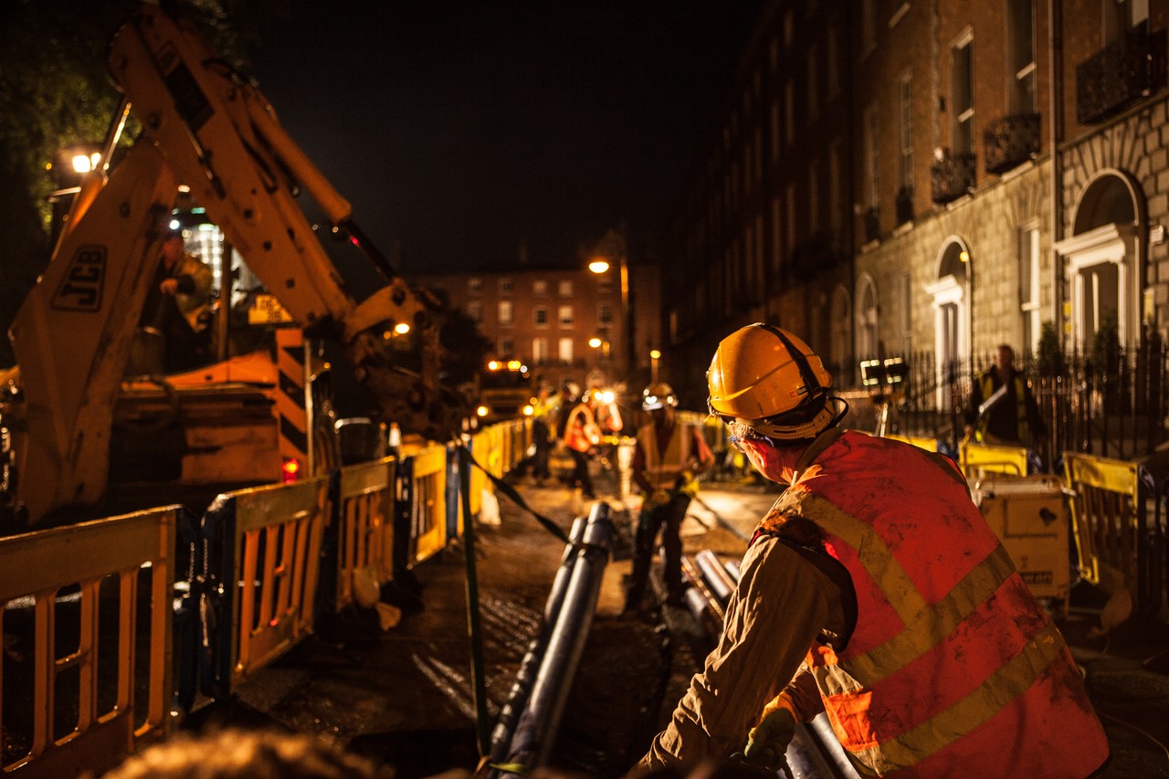 A worker working with pipes at night time