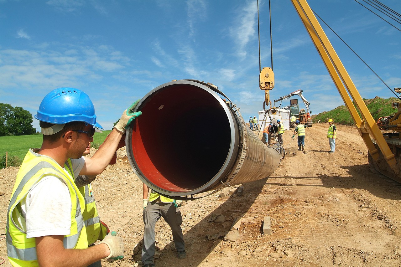 A man holding a water pipe on a construction site