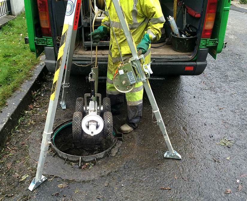 A worker surveying a sewer