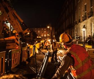 An Uisce Éireann worker working with pipes at night